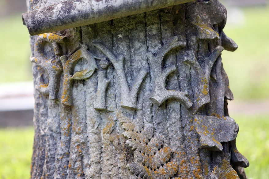 In this Wednesday, June 9, 2016 photo, a detail of Peter P. Spivey's Woodmen of the World memorial at Cedar Hill Cemetery in Suffolk, Va., shows the family named spelled out in the likeness of wooden branches. (Steve Earley/The Virginian-Pilot via AP)