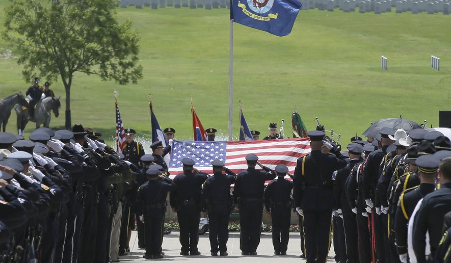 Members of an honor guard salute as the flag is lifted off of the coffin holding slain Dallas police officer Patrick Zamarripa during a ceremony at Dallas-Fort Worth National Cemetery in Dallas, Saturday, July 16, 2016. Zamarripa was one of five officers killed last week by a lone gunman during a protest march in Dallas. (AP Photo/LM Otero)