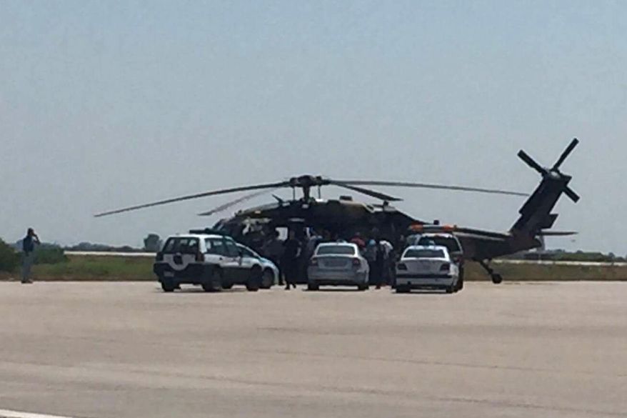 Greek policemen check a Turkish Blackhawk helicopter after landing at the airport of Alexandroupolis, northeastern Greece, on Saturday, July 16, 2016. Greece's defense ministry says a Blackhawk military helicopter carrying seven Turkish military personnel and one civilian has landed at the airport in the city of Alexandroupolis in northeastern Greece. The passengers have asked for asylum. They were arrested for illegal entry into Greece. (E-evros.gr via AP)