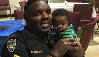 In a post accompanied by his holding his newborn son, Baton Rouge Police Officer Montrell Jackson described himself as &quot;tired physically and emotionally&quot; but swore he&#39;d not give in. (Associated Press)