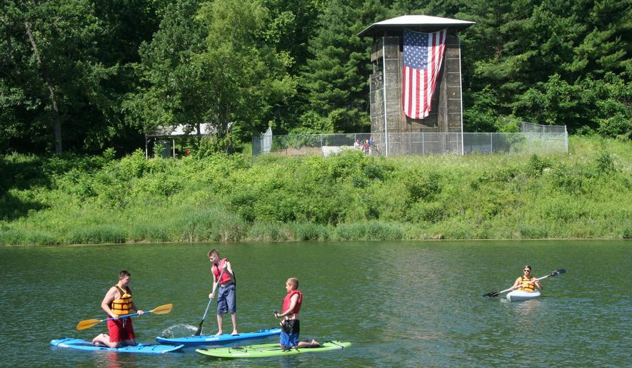 In this June 23, 2016 photo, Boy Scouts try the paddleboards and kayak on Lake John Deere at Camp C.S. Klaus, near Colesburg, Iowa. In 1955, a Boy Scout troop asked permission to use the grounds for camping. The Scouts concluded cleaned up their own campsite and picked up trash throughout the valley.(Mike Day/Telegraph Herald via AP)