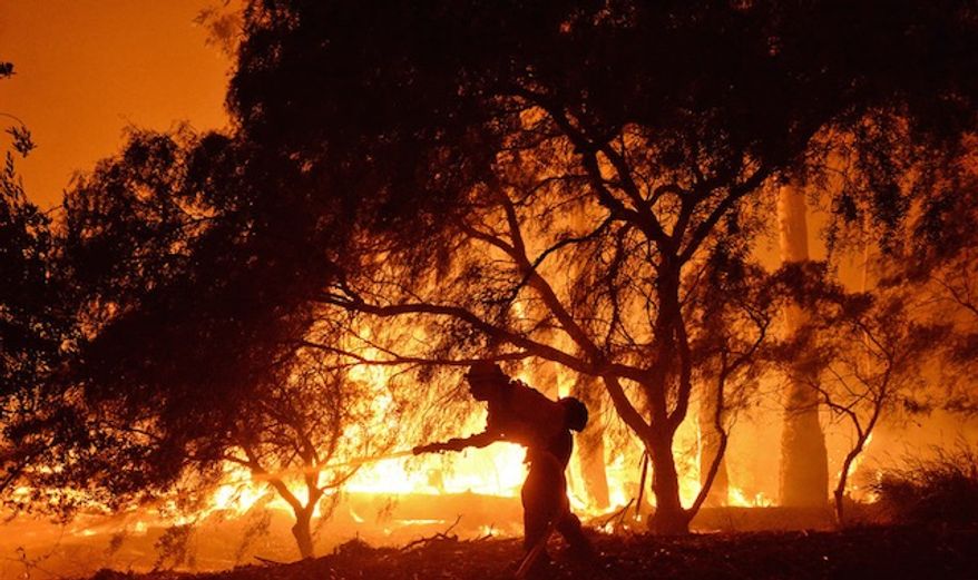 A firefighter battles flames near the Las Flores Canyon area west of Goleta, Calif., June 16, 2016. (Mike Eliason/Santa Barbara County Fire Department via AP) ** FILE **