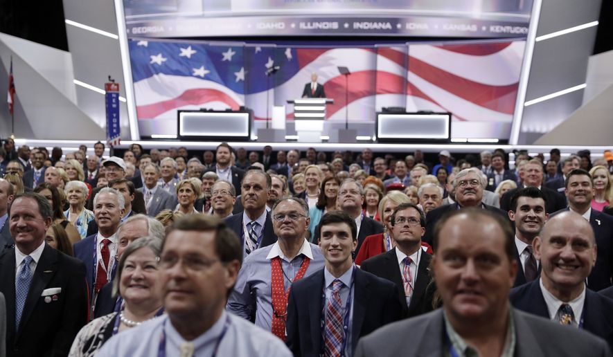 Delegates stand and turn toward the camera for the official photo during the opening day of the Republican National Convention in Cleveland, Monday, July 18, 2016. (AP Photo/John Locher)