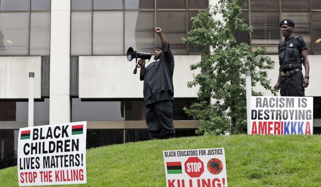 In this July 16, 2016 photo, people participate in a rally against racism, injustice and white supremacy, in Perk Park, before the Republican National Convention, in Cleveland, Ohio.  As Republicans prepare to convene their presidential nominating convention in Ohio, some prominent party figures are reaching anew for sensitivity after the latest racially tinged gun violence that left two more black men dead at the hands of police and five Dallas police officers struck down by the retaliatory bullets of a black sniper.  (AP Photo/Alex Brandon)