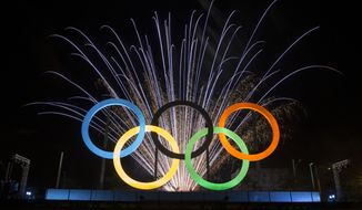 Fireworks explode behind the Olympic rings during their inauguration ceremony on May 20, 2015, at Madureira Park in Rio de Janeiro, Brazil. (Associated Press)