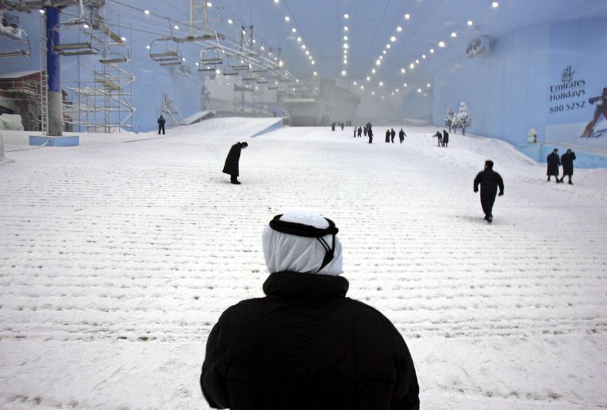 FILE - In this Oct. 25, 2005 file photo, Younis Al Mulla, General manager of Mall of the Emirates & Ski Dubai stands (with back to camera) viewing the snow covered slope at Ski Dubai complex as they have started to make real snow to prepare for the launch of first ski season in Dubai, United Arab Emirates. Visitors to Dubai have a new way to keep cool during the scorching Mideast summer. The company behind the city’s indoor ski slope plans to let guests stay overnight in tents on the man-made snow on Fridays starting from July 29, 2016. (AP Photo/Kamran Jebreili, File)