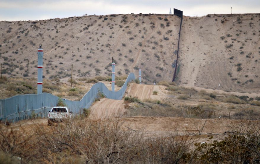 FILE - In this Jan. 4, 2016 file photo, a U.S. Border Patrol agent drives near the U.S.-Mexico border fence in Sunland Park, N.M. A new Cronkite News-Univision News-Dallas Morning News Border Poll released Monday, July 18, 2016, says a majority of residents surveyed on both sides of the U.S.-Mexico border are against the building of a wall between the two countries. The poll also suggests residents feel Democrats and Republicans are ignoring their concerns and aren't proposing solutions to help their economy and combat drug trafficking and human smuggling. (AP Photo/Russell Contreras, File)