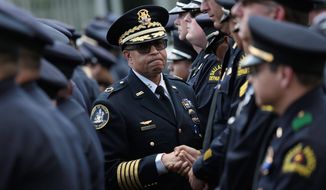 Detroit Police Chief James Craig (center) greets Dallas police officers after the funeral for one of the city&#x27;s five officers slain this month by a gunman. Police officers across the country are facing even more threats. (Associated Press)