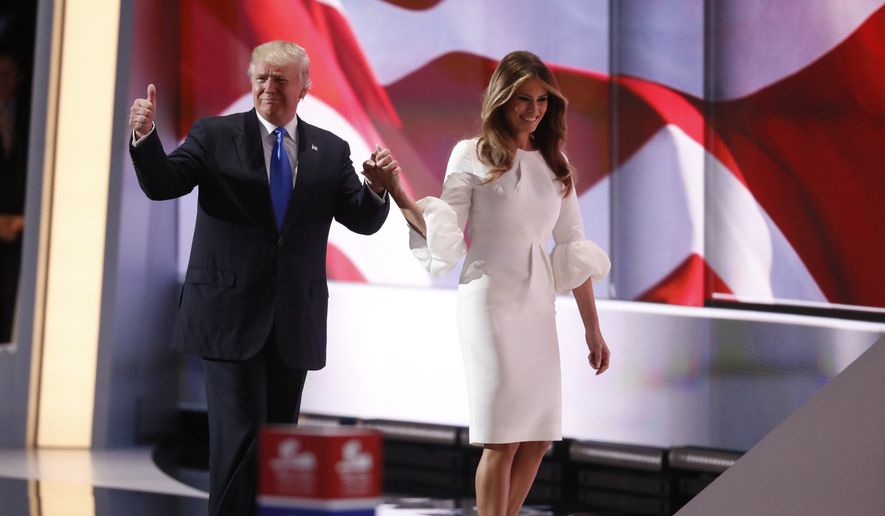 Republican presidential candidate Donald Trump walks wife Melania on stage during the opening day of the Republican National Convention in Cleveland, Monday, July 18, 2016. (AP Photo/Paul Sancya)