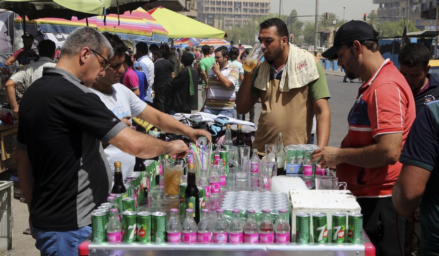 People cool off the summer heat by drinking iced juice in Baghdad, Iraq, Wednesday, July, 20, 2016. Iraqis are enduring the year&#x27;s hottest day to date, with temperatures soaring to 51 Celsius degrees (123.8 Fahrenheit) in Baghdad and as much as 53 Celsius (127.4 Fahrenheit) in the southern part of the country. (AP Photo/Karim Kadim)