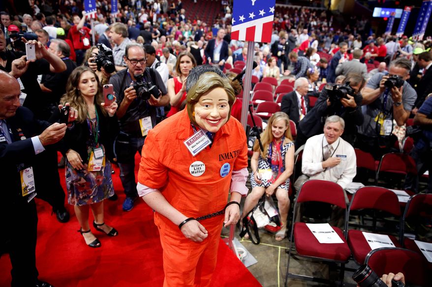 Michigan delegate Wes Nakagiri, dressed in a jumpsuit with a Hillary Clinton mask, draws attention from the media on the final day of Republican National Convention. (Associated Press)