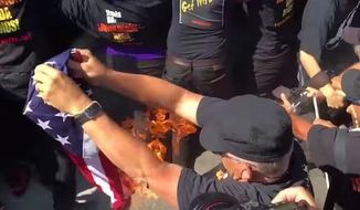A protester at the Republican convention in Cleveland lights the American flag on fire. (YouTube, We Are Change)