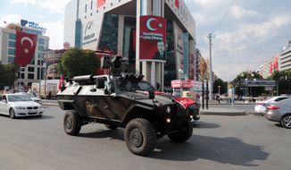 A police APC drives in Kizilay Square with a poster of Turkey&#39;s President Recep Tayyip Erdogan in the background in Ankara, Turkey, Thursday, July 21, 2016. The stunning sweep of Turkeys crackdown following an attempted coup last week forces questions about how far President Recep Tayyip Erdogan will go to cement his personal power at the expense of accepted democratic ideals. (AP Photo/Burhan Ozbilici)