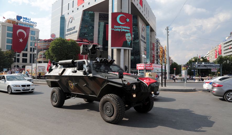 A police APC drives in Kizilay Square with a poster of Turkey&#x27;s President Recep Tayyip Erdogan in the background in Ankara, Turkey, Thursday, July 21, 2016. The stunning sweep of Turkeys crackdown following an attempted coup last week forces questions about how far President Recep Tayyip Erdogan will go to cement his personal power at the expense of accepted democratic ideals. (AP Photo/Burhan Ozbilici)