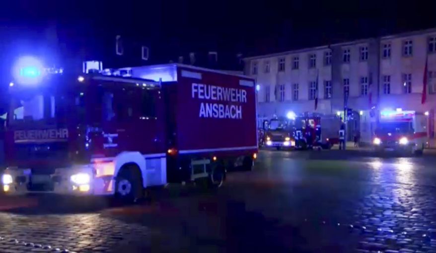 Fire trucks and ambulances stand in the city center of Ansbach, Germany, on Monday morning after a man was killed when an explosive device he was believed to be carrying went off near an open-air music festival, injuring 10 others. (News5 via Associated Press)