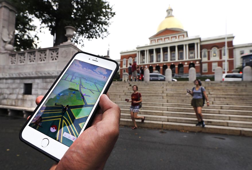 In this Monday, July 18, 2016, photo, a Pokemon Go player shows his mobile phone while walking through the Boston Common, outside the Massachusetts Statehouse in Boston. Historical markers dot the landscape of old cities, barely noticed by passers-by. The founder of the volunteer-based historical markers website that licensed its data to game-maker Niantic Labs five years ago said he hopes enough people take their eyes off the Pokemon they’re trying to catch to read the history on the markers. On the opposite side of the wall, left, is a bronze memorial to Robert Gould Shaw and the 54th Regiment Massachusetts Volunteer Infantry, comprised of black Union soldiers who fought in the Civil War. (AP Photo/Charles Krupa)