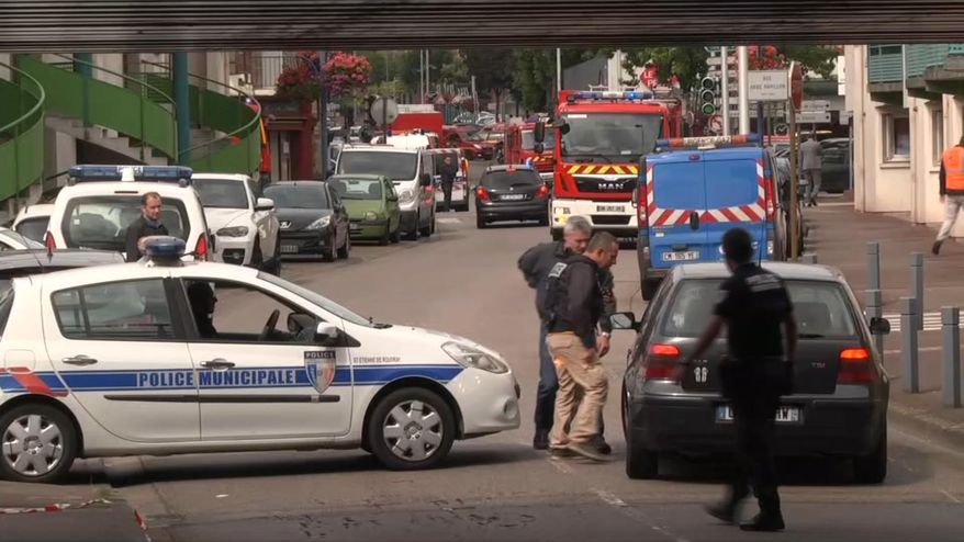 In this grab made from video, police officers speak to a driver as they close off a road during a hostage situation in Normandy, France, Tuesday, July 26, 2016. Two attackers seized hostages in a church near the Normandy city of Rouen on Tuesday, killing one hostage by slitting their throat before being killed by police, a security official said. The identities of the attackers and motive for the attack are unclear, according to the official, who was not authorized to be publicly named. (BFM via AP)