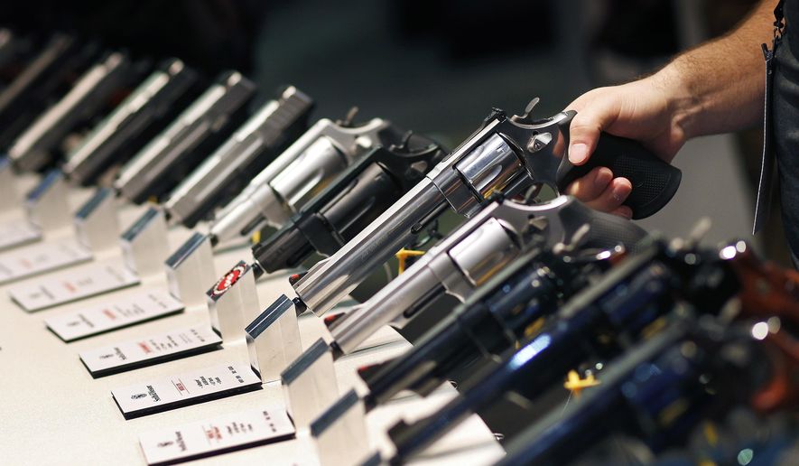 FILE - In this Jan. 19, 2016 file photo, handguns are displayed at the Smith &amp;amp; Wesson booth at the Shooting, Hunting and Outdoor Trade Show in Las Vegas. Nearly two-thirds of Americans expressed support for stricter gun laws, according to an Associated Press-GfK poll released Saturday, July 23, 2016. A majority of poll respondents oppose banning handguns. (AP Photo/John Locher, File)