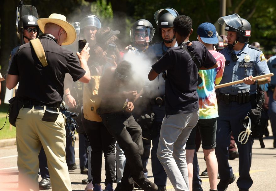 16-year old Tayvion Owens is sprayed with a substance by St. Paul police officers as they and protesters face off on Summit Ave., a block from the Governor's residence, in St. Paul, Minn. on Tuesday, July 26, 2016. Police have arrested an unknown number of protesters in front of the governor's mansion on St. Paul's Summit Avenue. Demonstrators have been camping outside the governor's residence since early July 7, a day after the shooting of Philando Castile, who was killed by a St. Anthony police officer during a traffic stop. (Scott Takushi/Pioneer Press via AP)