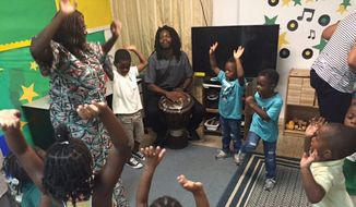 Children form a drum circle to learn African drumming, music and dance from teaching artists Sylvia Soumah and Abdou Muhammad for Inner City-Inner Child, an arts outreach program. (Aubri Juhasz/The Washington Times)