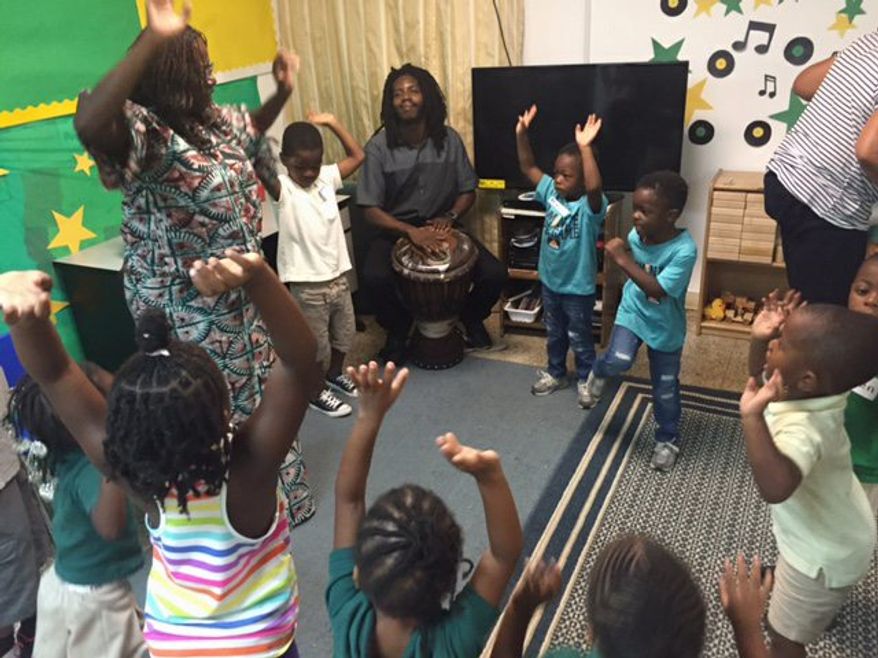 Children form a drum circle to learn African drumming, music and dance from teaching artists Sylvia Soumah and Abdou Muhammad for Inner City-Inner Child, an arts outreach program. (Aubri Juhasz/The Washington Times)
