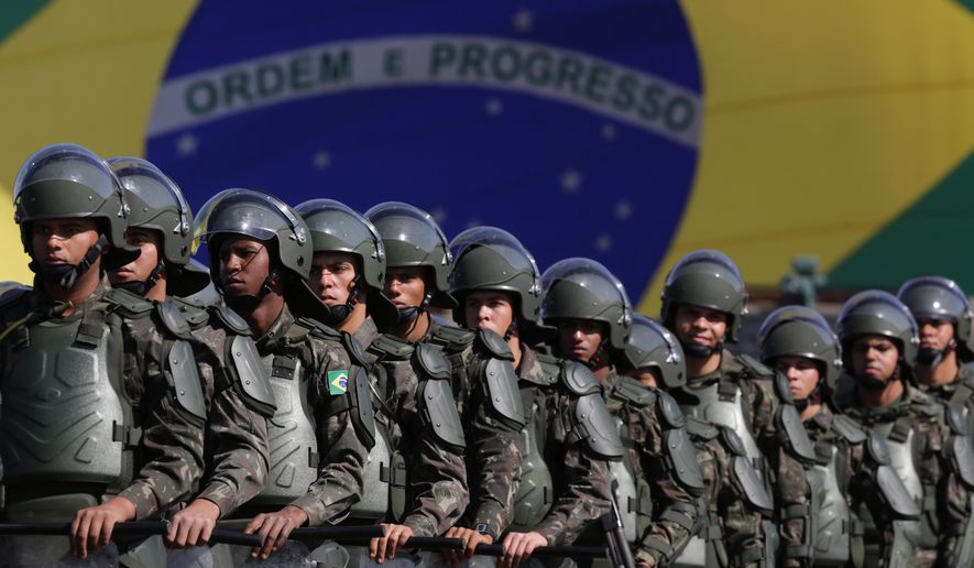 FILE - In this July 22, 2016 photo, Brazilian Army soldiers take part in military exercise during presentation of the security forces for the Rio 2016 Olympic Games, in front of the National Stadium, in Brasilia, Brazil. Security has emerged as the top concern during the Olympics, including violence possibly spilling over from Rio&#x27;s hundreds of slums. Authorities have said 85,000 police officers and soldiers will be patrolling during the competitions. (AP Photo/Eraldo Peres, File)