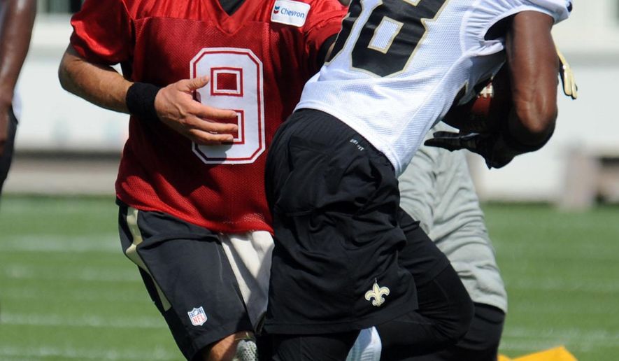 New Orleans Saints quarterback Drew Brees (9) hands the ball off  to a teammate during the NFL football teams training camp in White Sulphur Springs, W.Va., Thursday, July 28, 2016. (AP Photo/Chris Tilley)