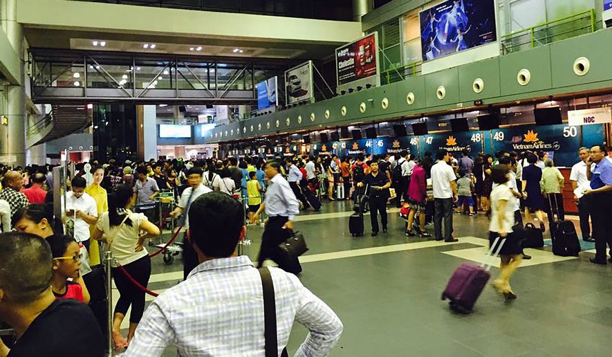 Passengers crowd at check-in counters at Noi Bai Airport in Hanoi, Vietnam Friday, July 29, 2016. Screens displaying flight information at Vietnam&#39;s two major airports, Noi Bai and Tan Son Nhat in Ho Chi Minh City,  were hacked Friday to contain distorted information about the South China Sea and insult Vietnam and the Philippines, state media reported. (AP Photo)