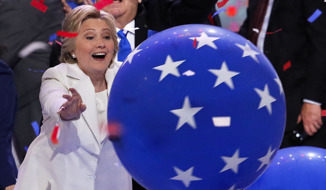 Democratic presidential nominee Hillary Clinton reaches for a falling balloon at the conclusion of the Democratic National Convention in Philadelphia , Thursday, July 28, 2016. (AP Photo/J. Scott Applewhite)