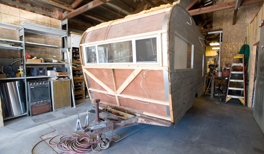 ADVANCE FOR USE SATURDAY, JULY 30, 2016 AND THEREAFTER - This June 29, 2016 photo, shows the exterior of a 1964 Trotwood camper being restored for a vendor by Greg Patterson at Classy Chassis Vintage Camper Sales in Mattoon, Ill. It was four years ago when vintage camper trailers first caught Greg and his wife Lisa's attention. Last year Patterson left his left his job in construction and started rebuilding vintage campers full time. He also is developing his own line of vintage-style campers. (Kevin Kilhoffer/Journal Gazette via AP)