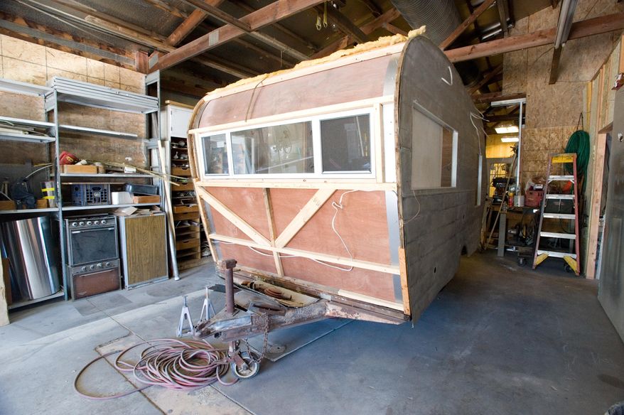 ADVANCE FOR USE SATURDAY, JULY 30, 2016 AND THEREAFTER - This June 29, 2016 photo, shows the exterior of a 1964 Trotwood camper being restored for a vendor by Greg Patterson at Classy Chassis Vintage Camper Sales in Mattoon, Ill. It was four years ago when vintage camper trailers first caught Greg and his wife Lisa's attention. Last year Patterson left his left his job in construction and started rebuilding vintage campers full time. He also is developing his own line of vintage-style campers. (Kevin Kilhoffer/Journal Gazette via AP)