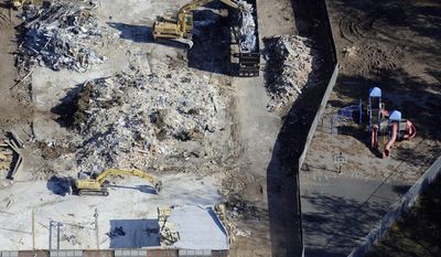 In this Oct. 28, 2013, aerial file photo, workers use backhoes to remove rubble during the demolition of Sandy Hook Elementary School in Newtown, Conn., where gunman Adam Lanza killed 20 children and six adult educators on Dec. 14, 2012. An open house for the new school, erected on the same site, is set for Friday, July 29, 2016. (AP Photo/Jessica Hill, File)