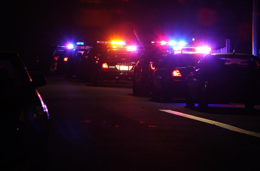Police cars line the scene near the corner of 39th Street and Boston Avenue in San Diego near where two police officers were shot Thursday night, July 28, 2016. (John Gastaldo/The San Diego Union-Tribune via AP)