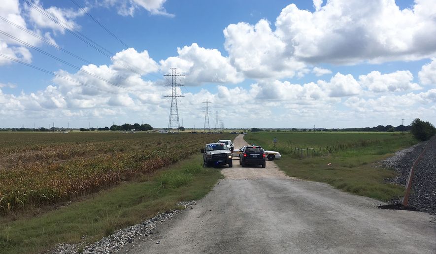 Police cars block access to the site where a hot air balloon crashed early Saturday, July 30, 2016, near Lockhart, Texas.  At least 16 people were on board the balloon, which Federal Aviation Administration spokesman Lynn Lunsford said caught fire before crashing into a pasture shortly after 7:40 a.m. Saturday near Lockhart. No one appeared to survive the crash, authorities said. (AP Photo/James Vertuno)