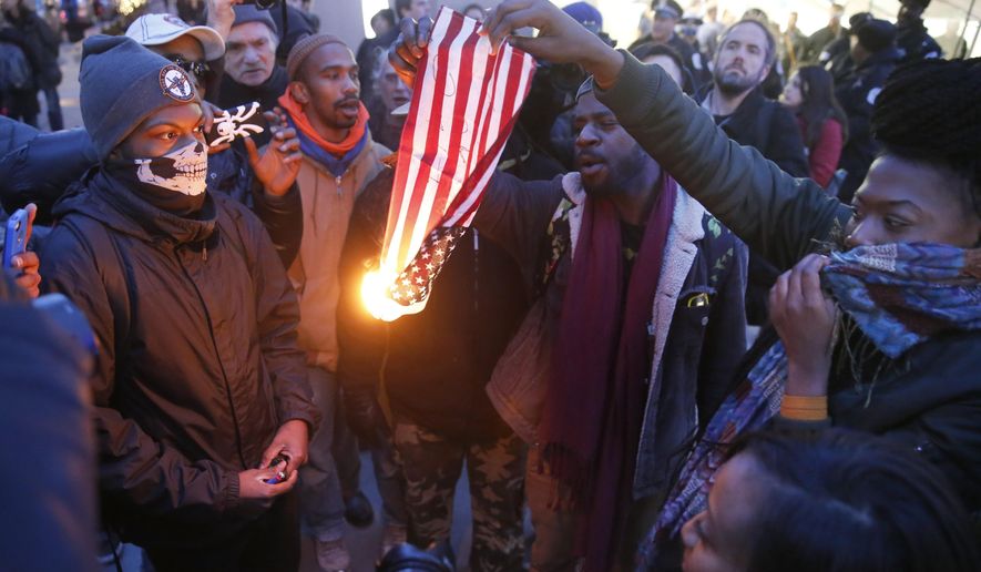 In this Feb. 23, 2016 file photo, protesters burn an American flag in Chicago. Champaign County Ill. (AP Photo/Charles Rex Arbogast, File)