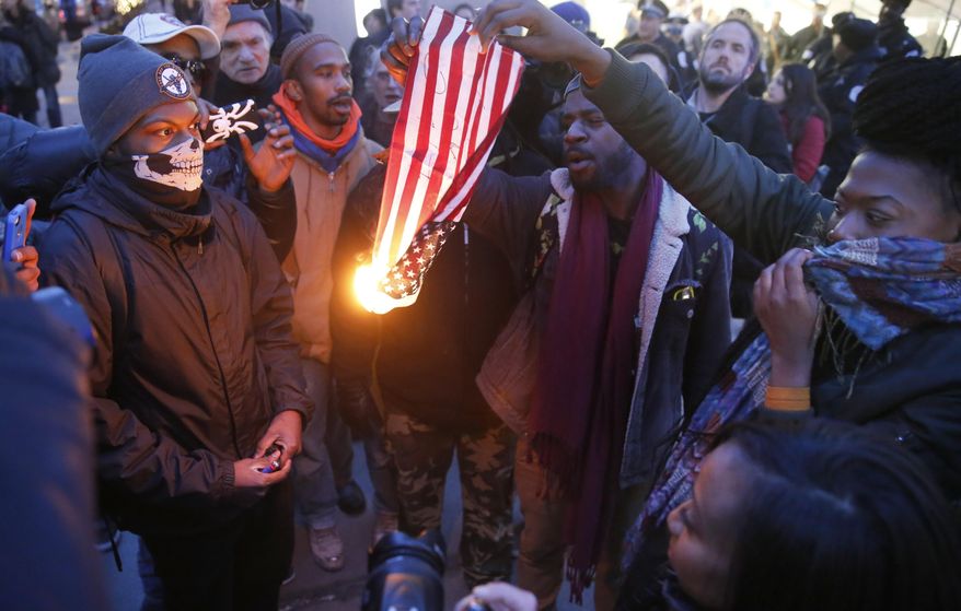 In this Feb. 23, 2016 file photo, protesters burn an American flag in Chicago. Champaign County Ill. (AP Photo/Charles Rex Arbogast, File)