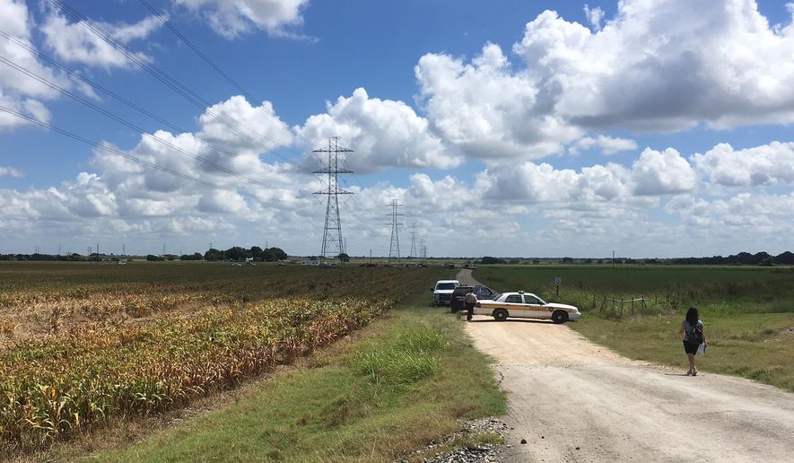 Police cars block access to the site where a hot air balloon crashed early Saturday, July 30, 2016, near Lockhart, Texas. At least 16 people were on board the balloon, which Federal Aviation Administration spokesman Lynn Lunsford said caught fire before crashing into a pasture shortly after 7:40 a.m. Saturday near Lockhart. No one appeared to survive the crash, authorities said. (AP Photo/James Vertuno)