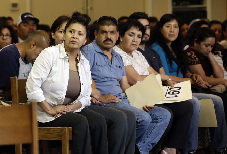 In this photo taken Wednesday, July 13, 2016 Esperanza Moreno, left, listens carefully during a Faith Action ID drive at Holy Family Catholic Church in Hillsborough, N.C. Moreno, of Durham, was one of more than 200 people with no legal U.S. identification learning how to use their new $10 ID cards to communicate with police. The FaithAction ID program has issued more than 7,000 ID cards, recognized by police and some local organizations in 16 cities and 9 counties. (AP Photo/Gerry Broome)