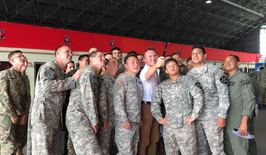 U.S Army Secretary Eric Fanning, fourth from right, takes a selfie with fellow personnel during an annual joint military exercise with the Malaysian army in Johore Bahru, Malaysia, Saturday, July 30, 2016. Fanning says annual war games between the United States and South Korea will go ahead next month, despite North Korea's warning of a "vicious" showdown if the military drills proceed. (AP Photo/Eileen Ng)