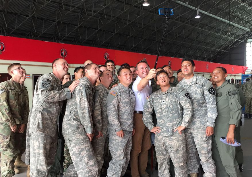 U.S Army Secretary Eric Fanning, fourth from right, takes a selfie with fellow personnel during an annual joint military exercise with the Malaysian army in Johore Bahru, Malaysia, Saturday, July 30, 2016. Fanning says annual war games between the United States and South Korea will go ahead next month, despite North Korea's warning of a "vicious" showdown if the military drills proceed. (AP Photo/Eileen Ng)