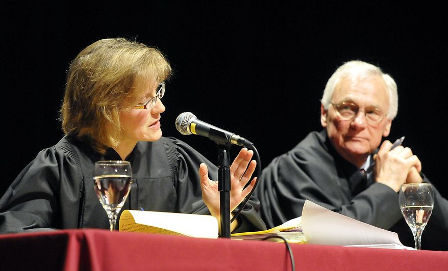 In this April 12, 2013 photo, Montana Supreme Court Justice Beth Baker asks a question as Justice Mike Wheat listens during oral arguments at the Dennison Theatre on the University of Montana campus in Missoula, Mont. Lawmakers will review a loophole in Montana’s incest law that allows 16- and 17-year-olds to be held as complicit as their parents. (Tom Bauer/The Missoulian via AP)