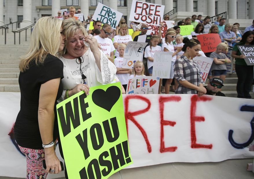 Laurie Holt, right, the mother of Josh Holt, an American jailed in Venezuela, is comforted by family friend Lori Fitch, left, as she cries during a rally at the Utah State Capitol Saturday, July 30, 2016, in Salt Lake City. Laurie Holt hosted the rally in hopes of drawing attention to her son's case. Laurie Holt says her son was mistakenly accused, and has lost weight and gotten sick since he was jailed nearly a month ago. Josh Holt was arrested on suspicion of weapons charges after he traveled to Venezuela on a tourist visa to marry a fellow Mormon he met on the internet. More than 100 rallied at the Utah State Capitol. (AP Photo/Rick Bowmer)