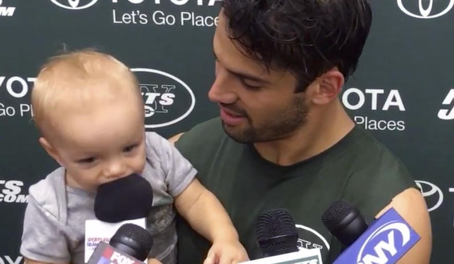 In this image from video, New York Jets wide receiver Eric Decker holds his 11-month-old son Eric II while addressing reporters after training camp practice in Florham Park, N.J., Sunday, July 31, 2016. (AP Photo/Dennis Waszak)