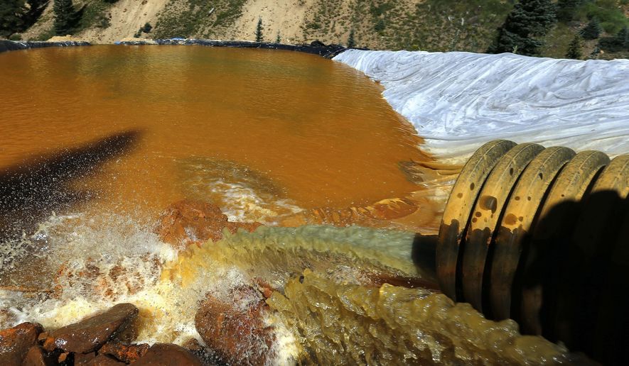 In this Aug. 14, 2015, file photo, water flows through a series of retention ponds built to contain and filter out heavy metals and chemicals from the Gold King mine chemical accident, in the spillway about a quarter mile downstream from the mine, outside Silverton, Colo. (AP Photo/Brennan Linsley, File)