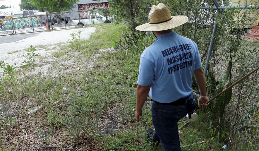 An inspector with the Miami-Dade County mosquito control department looks for pools of standing water, which often serve as a breeding ground for the Zika-carrying insects. (Associated Press)