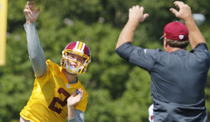 Washington Redskins head coach Jay Gruden, right, provides defense as quarterback Nate Sudfeld (2), makes a pass during the afternoon practice at the Washington Redskins NFL football teams training camp in Richmond, Va., Friday, July 29, 2016. (AP Photo/Steve Helber)
