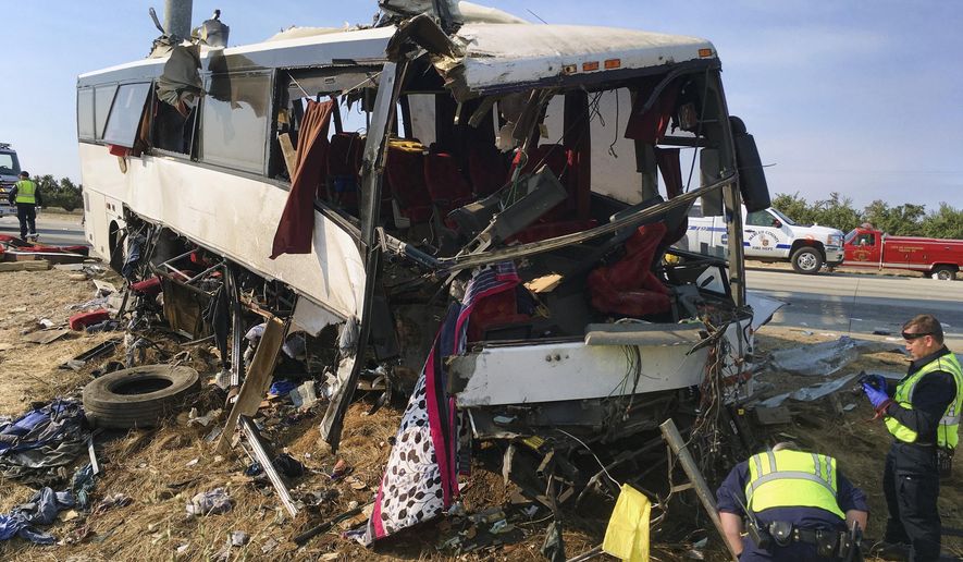 Authorities investigate the scene of a charter bus crash on northbound Highway 99 between Atwater and Livingston, Calif., Tuesday, Aug. 2, 2016. A charter bus veered off a central California freeway before dawn Tuesday and struck a pole that sliced the vehicle nearly in half, killing multiple people and sending at least five others to hospitals, authorities said. (AP Photo/Scott Smith)