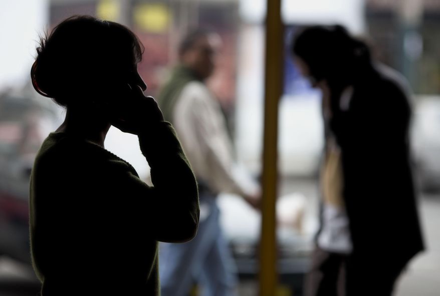 Pedestrians talk on their cellphones in Lima, Peru, on Monday, Aug. 1, 2016. Under a July 2015 decree, police now track cellphone locations without a court order but would need one to listen in. All four Peruvian phone companies are cooperating. They signed a pact with the government in Octoboer the details of which were not disclosed. (AP Photo/Martin Mejia)