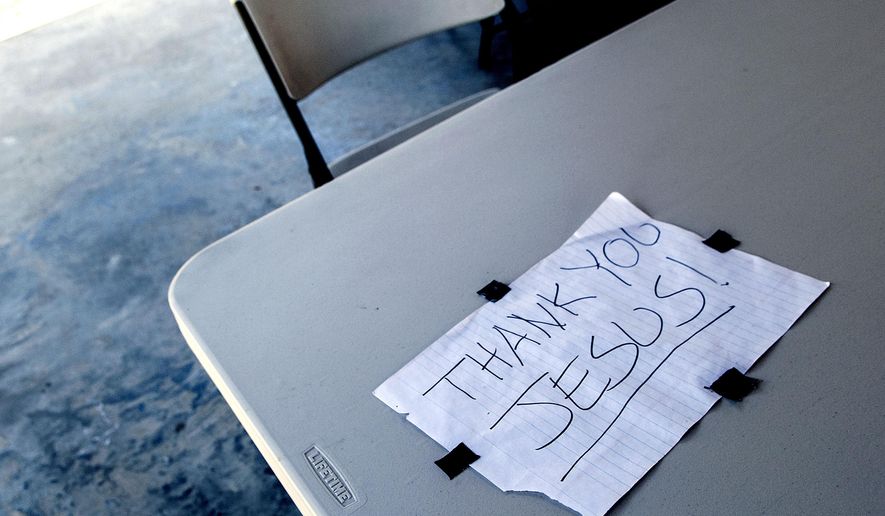This sign was taped to a plastic table outside the former site of St. Ann's Catholic Church in Bonners Ferry, Idaho on Wednesday, July 27, 2016. An arson blaze burned the church to the ground April 21, 2016. (Kathy Plonka/The Spokesman-Review via AP)