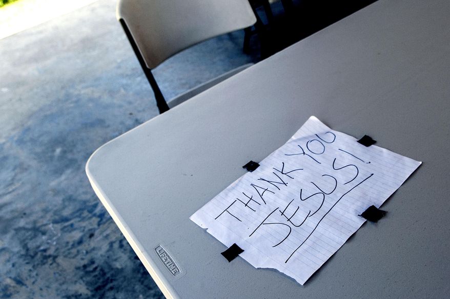 This sign was taped to a plastic table outside the former site of St. Ann's Catholic Church in Bonners Ferry, Idaho on Wednesday, July 27, 2016. An arson blaze burned the church to the ground April 21, 2016. (Kathy Plonka/The Spokesman-Review via AP)